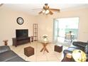 Cozy living room features tile floors, ceiling fan and access to a screened lanai with outdoor seating at 117 114Th N Ave # 117, St Petersburg, FL 33716