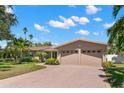 Brick house with a two-car garage and a large, well-maintained lawn at 237 2Nd W St, Tierra Verde, FL 33715