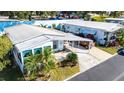 Aerial view of a manufactured home with a carport and landscaping at 37827 Mission Hills Ave, Zephyrhills, FL 33541