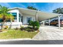 Single-wide manufactured home with carport, landscaping, and paved driveway at 37827 Mission Hills Ave, Zephyrhills, FL 33541
