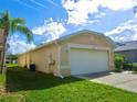 Side view of tan house with garage at 11338 Cocoa Beach Dr, Riverview, FL 33569