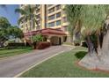 Beautifully landscaped entry way to the building with covered entrance and lush foliage at 700 Island Way # 106, Clearwater Beach, FL 33767