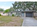 Single-story home with a driveway, attached garage, and landscaped yard at 664 Frederica Ln, Dunedin, FL 34698