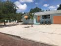 Charming teal home with a gravel driveway and mature trees at 2658 48Th S St, Gulfport, FL 33711