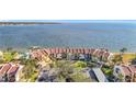 Aerial view of waterfront condo with private beach access, lush landscaping, and nearby covered parking at 7520 Sunshine Skyway S Ln # 210, St Petersburg, FL 33711