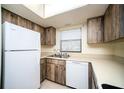 Kitchen with white appliances and wood cabinets at 101 Lake Ne Ave # 211, Largo, FL 33771