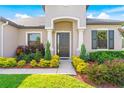 House entrance with dark-colored door, white columns, and colorful landscaping at 913 Buckhurst Dr, Spring Hill, FL 34609
