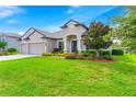 Two-story house with three-car garage, manicured lawn, and mature trees at 913 Buckhurst Dr, Spring Hill, FL 34609