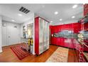 Modern red kitchen with stainless steel appliances and hardwood floors at 1 Beach Se Dr # 2007, St Petersburg, FL 33701