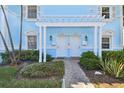 Front view of a light blue building with two entrances, a pergola, and nicely landscaped grounds at 3825 Pompano Se Dr, St Petersburg, FL 33705