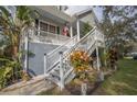 Two-story house with a wrap-around porch, white railings, and landscaping at 9815 Golden Loop, New Port Richey, FL 34654