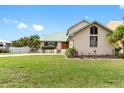 Tan house with green roof, landscaping, and driveway at 1104 Kingfish Pl, Apollo Beach, FL 33572