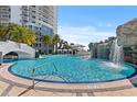 Resort-style pool with waterfall feature, palm trees, and a nearby high rise offers a luxurious living experience at 1209 E Cumberland Ave # 508, Tampa, FL 33602