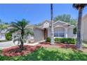Charming one-story home featuring a well-manicured lawn, mature trees, and tasteful landscaping at 15501 Pepper Pine Ct, Land O Lakes, FL 34638