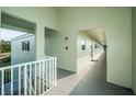 Building hallway with light-colored walls and white railings at 2293 Swedish Dr # 43, Clearwater, FL 33763