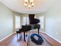 Elegant music room with a grand piano and bay windows at 4630 Pointe O Woods Dr, Wesley Chapel, FL 33543