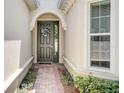 Charming entryway showcasing a brick path, decorative door, and an arched entrance with natural light at 1804 Pacific Dunes Dr, Sun City Center, FL 33573