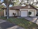 Front view of a twin home with a driveway and landscaping at 2672 Arjay Ct, Palm Harbor, FL 34684