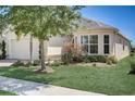Tan house with bay window, landscaping, and brick walkway at 1804 Pacific Dunes Dr, Sun City Center, FL 33573