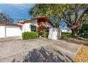 Single story home featuring a two-car garage and mature landscaping at 2390 Shelly Dr # D, Palm Harbor, FL 34684