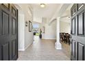 Bright and spacious entryway with tile flooring, high ceilings, and views into the dining and living areas at 4538 Pointe O Woods Dr, Wesley Chapel, FL 33543