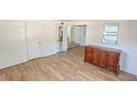 Living room featuring wood-look floors, fresh paint, and access to the kitchen and other areas of the home at 527 4Th Nw Ave, Largo, FL 33770