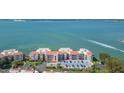 A view of the condo building with parking spaces and a water view in the background at 5825 Puerta Del Sol S Blvd # 170, St Petersburg, FL 33715