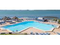 A refreshing pool with comfortable lounge chairs, shaded umbrellas, and a scenic view of the ocean at 5825 Puerta Del Sol S Blvd # 170, St Petersburg, FL 33715