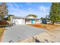 Newly renovated home with a teal front door and a spacious driveway at 8441 Paxton Dr, Port Richey, FL 34668