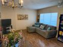 Living room with wood-look floors, sectional sofa, and large windows at 2459 Columbia Dr # 51, Clearwater, FL 33763