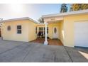 Bright yellow house with white door and garage, featuring a sun design at 6614 10Th Avenue S Ter, St Petersburg, FL 33707