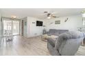 Cozy living room featuring a gray sofa, recliner, and light wood floors at 425 Treasure Rd, Venice, FL 34293