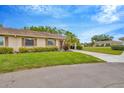 Well maintained single-story home showcasing verdant green landscaping and a long driveway leading to the carport at 2104 Hembury Pl # 33, Sun City Center, FL 33573