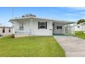 White single wide mobile home with carport and green driveway at 6054 Crestview Ln, Zephyrhills, FL 33542