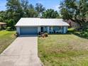 Well-kept single-story home featuring a metal roof, manicured lawn, and attached garage at 1467 Monte St, Port Charlotte, FL 33952