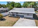 Aerial view of a gray single-story home showcasing the front yard and proximity to a screened pool enclosure at 5721 12Th S Ave, Gulfport, FL 33707