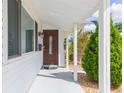 Covered front porch with a brown door and white columns at 907 La Jolla Ave, Sun City Center, FL 33573