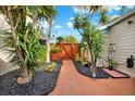 Landscaped side patio with wooden gate and walkway at 12809 Settlers Dr, Hudson, FL 34667