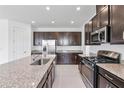 This kitchen features granite counters, stainless appliances, dark cabinets, and recessed lighting at 15876 Mulrion Blvd, Punta Gorda, FL 33982