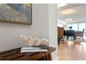 Bright entryway with wood bench, rug, and large abstract art at 800 Collany Rd # 303, St Petersburg, FL 33715