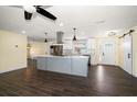 Modern kitchen with island, stainless steel appliances, and dark hardwood floors at 440 Mehlenbacher Rd, Belleair, FL 33756