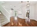 Spacious living room with hardwood floors, stairs, and a view into the kitchen at 14459 Mirabelle Vista Cir, Tampa, FL 33626