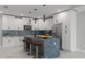 Modern kitchen with white cabinets and large island at 211 Dolphin Pt # 202, Clearwater Beach, FL 33767