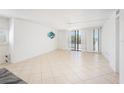 Bright living room featuring tile flooring, fan, and sliding doors to the balcony at 30 Turner St # 401, Clearwater, FL 33756