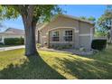 Stucco home featuring lush landscaping and a decorative rock garden bed at 35502 Welby Ct, Zephyrhills, FL 33541