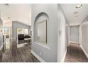 Open hallway with wood-look floors leading into the living room at 35502 Welby Ct, Zephyrhills, FL 33541