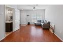 Living room with hardwood floors, gray sectional sofa, and access to a half bath at 2210 Lake Woodberry Cir, Brandon, FL 33510