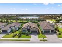 Beautifully landscaped home with a paver driveway and a lush green lawn overlooking a serene lake at 26810 Weiskopf Dr, Englewood, FL 34223