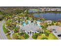 Aerial view of a community pool with multiple pools, palm trees, seating, and beautiful landscaping at 26810 Weiskopf Dr, Englewood, FL 34223