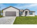 Single-story home with a gray exterior, two-car garage, and a nicely paved driveway and walkway at 5227 Dayton Ln, Port Charlotte, FL 33981